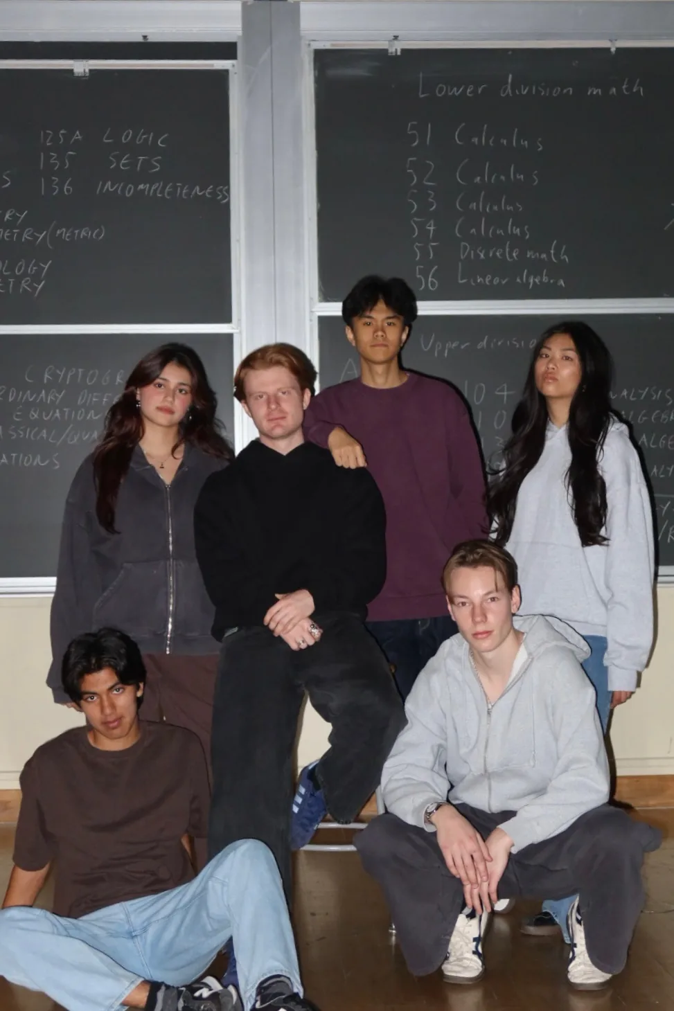 Six students wearing blank hoodies, crewnecks, and sweatpants in front of a chalkboard