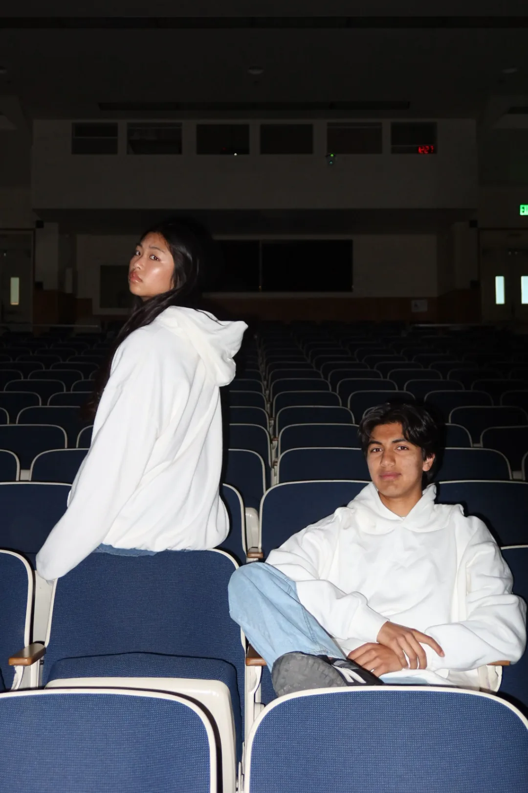 Two students wearing blank white heavyweight hoodies in a university lecture hall