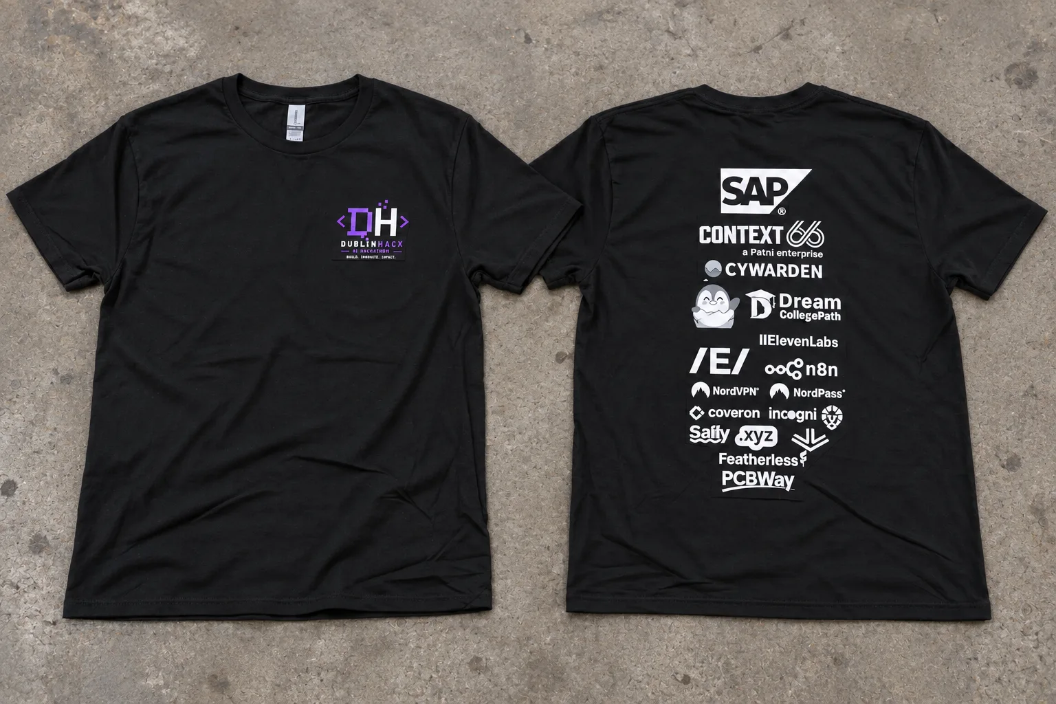 Front and back view of a black dublinhacx crewneck tee on a plain scuffed gray concrete factory floor under subdued overhead light, with a small purple-and-white DH coding logo on the left chest and a tall white sponsor stack on the back