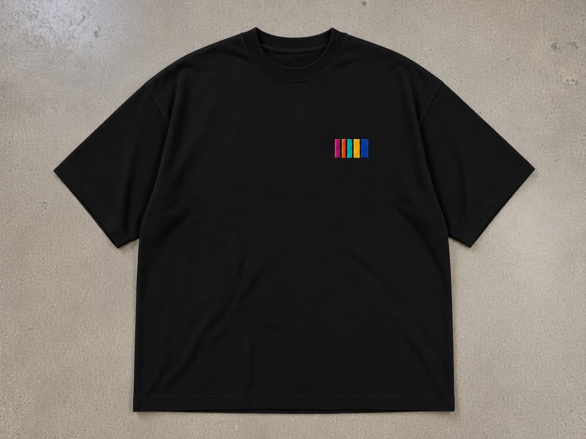Flat-lay studio photograph of a black Lane Seven LS16005 7.6 oz heavyweight boxy crewneck t-shirt on a concrete floor with a five-bar Hue logo embroidered on the left chest